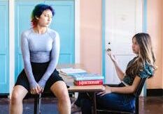 Two students having a discussion in a colorful classroom setting with study materials./pexels-photo-8419642-8419642