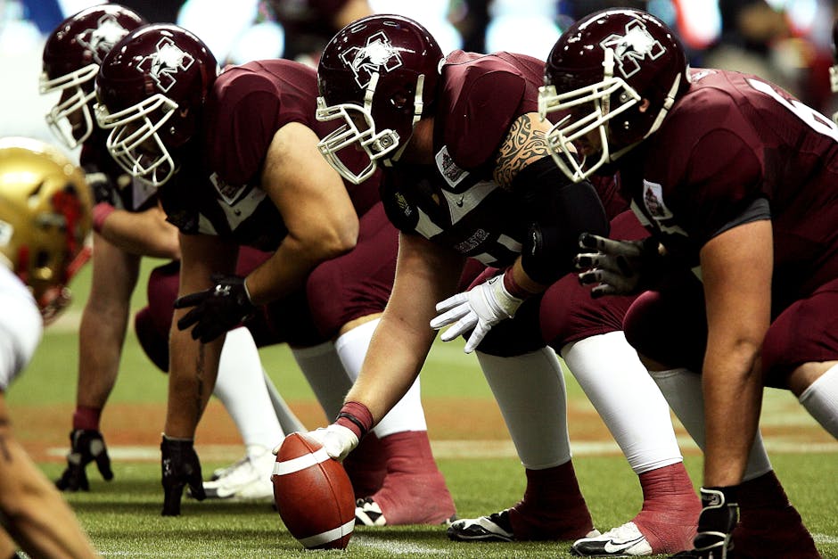 Dynamic shot of American football players in formation on the field, ready to start the game.
