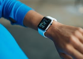 Focus on a smartwatch worn on an adult's wrist, showcasing its digital display.