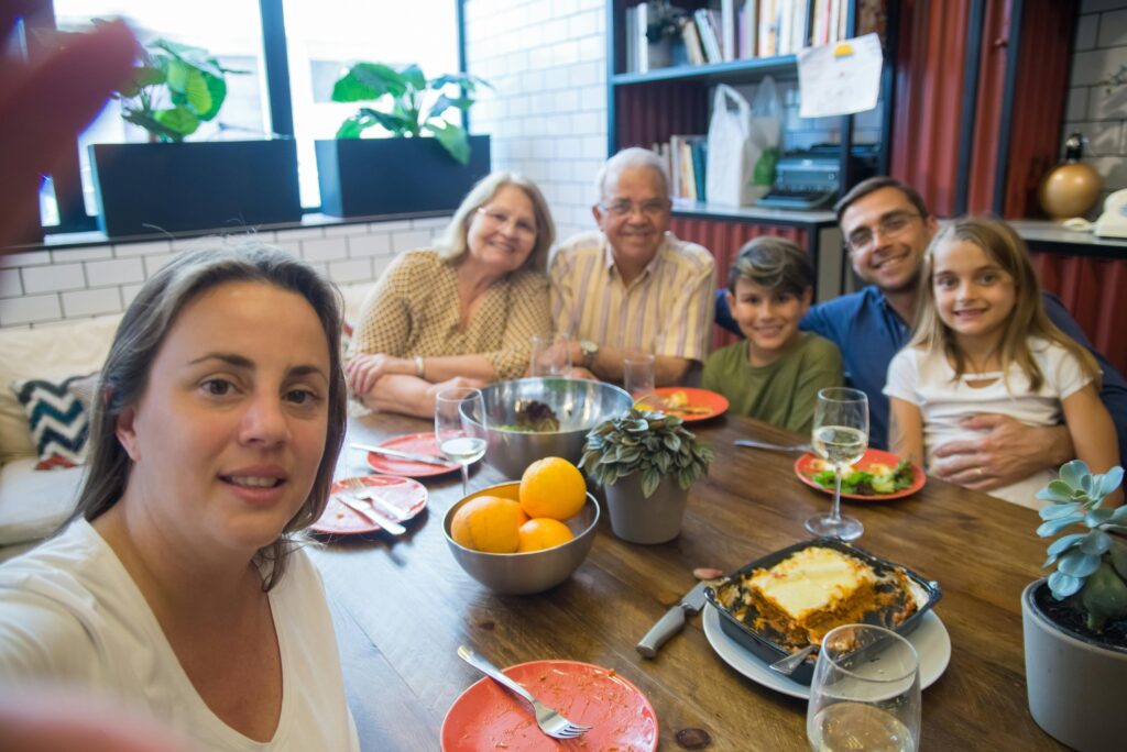 A joyful family enjoying a meal together at home with food and laughter.
